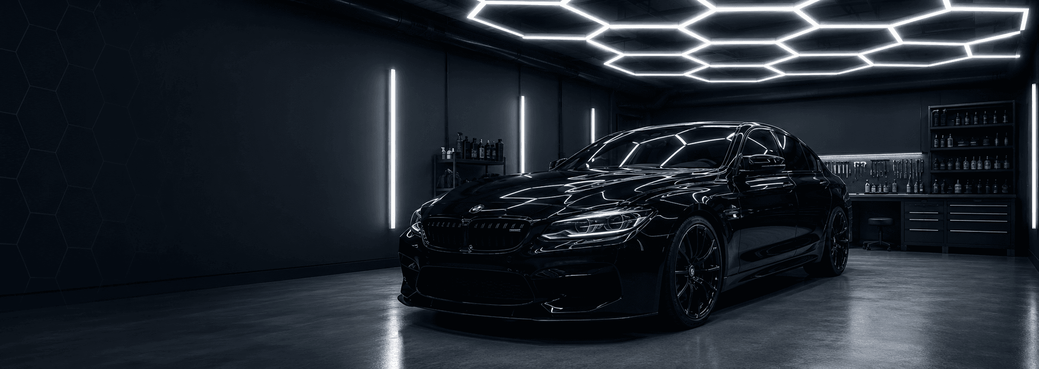 Black BMW in a garage with hexagon LED ceiling lights